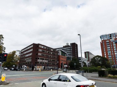 Manchester, İngiltere - 30 Eylül 2025: Manchester 'da şehir sokak manzarası tuğladan evler, arabalar ve kalabalık bir şehir arkaplanı.