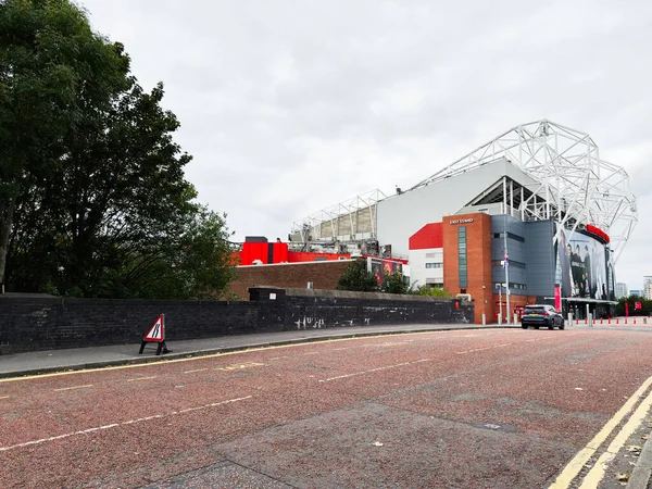 Manchester, İngiltere - 30 Eylül 2025: Manchester 'da kırmızı tuğlalı, beyaz iskeletli ve şehir manzaralı büyük bir stadyum.