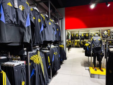 Manchester, İngiltere - 30 Eylül 2025: Koyu mavi ve sarı spor kıyafetleri ve bir mankenle kapalı mağaza sahnesi.