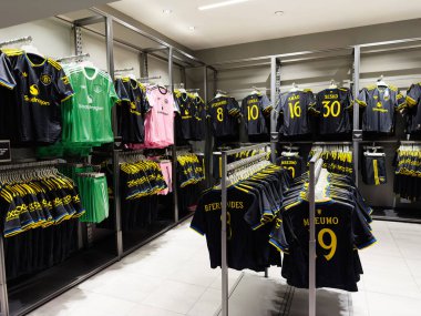 Manchester, İngiltere - 30 Eylül 2025: Vibrant Manchester mağazası mavi ve sarı futbol formaları, şortlar ve kaleci takımlarını raflarda güzelce sergiliyor.