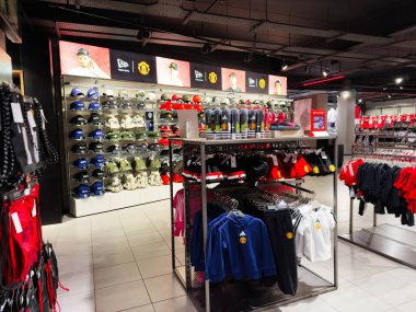 Manchester, İngiltere - 30 Eylül 2025: Manchester United giyim ve aksesuarlarını gösteren yoğun bir Manchester mağazası, şapkalar, şapkalar, gömlekler ve kapüşonlular.