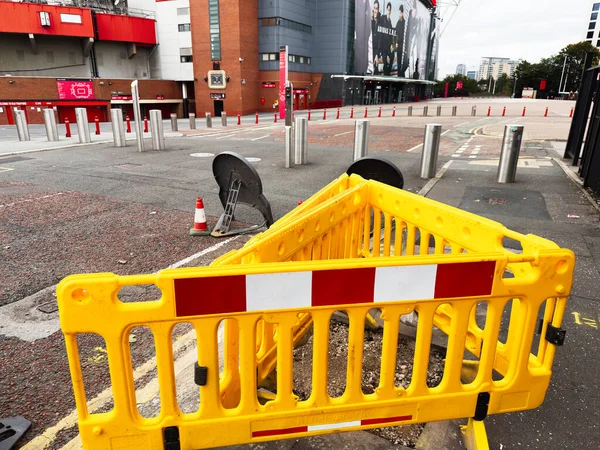 Manchester, İngiltere - 30 Eylül 2025: Manchester kentsel cadde kapanışı Parlak sarı bariyer ve güvenlik ekipmanları bir stadyum yakınında.