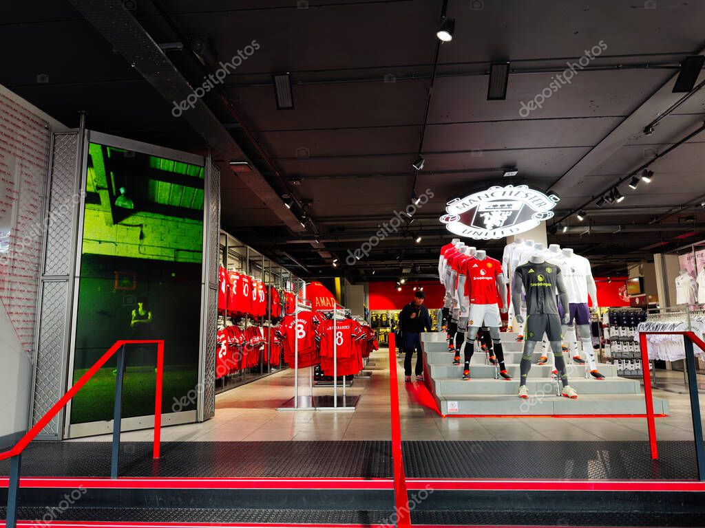 IManchester, UK - September 30, 2025: nside Manchester shop featuring football kits, mannequins, and bold team branding on display.