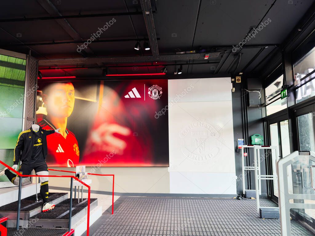 Manchester, UK - September 30, 2025: Retail display in Manchester featuring a life-size mannequin in red jersey beside banners and logos.