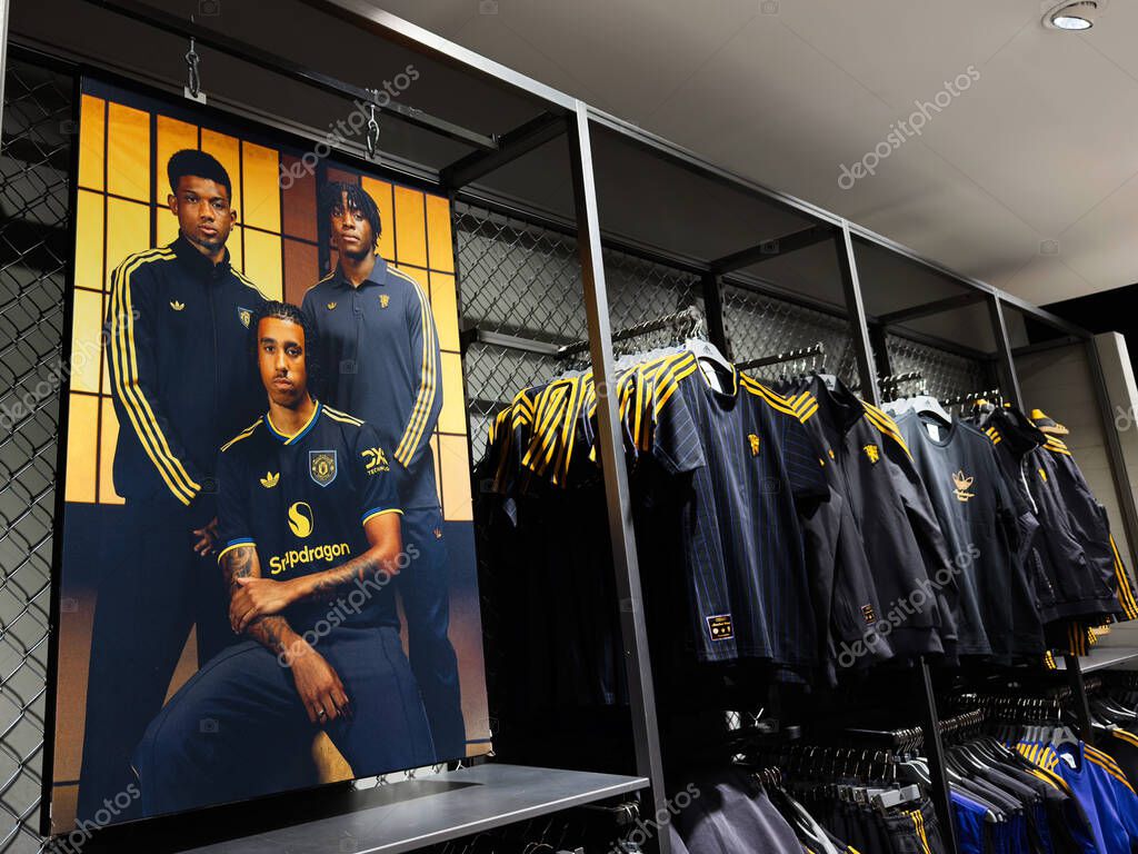 Manchester, UK - September 30, 2025: Shop scene in Manchester with blue and yellow football kits and a bold team portrait.