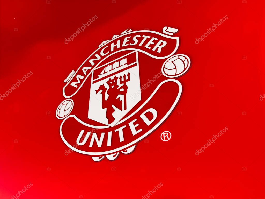 Manchester, UK - September 30, 2025: Manchester United crest on a bold red background, representing the iconic football club identity in Manchester, UK.