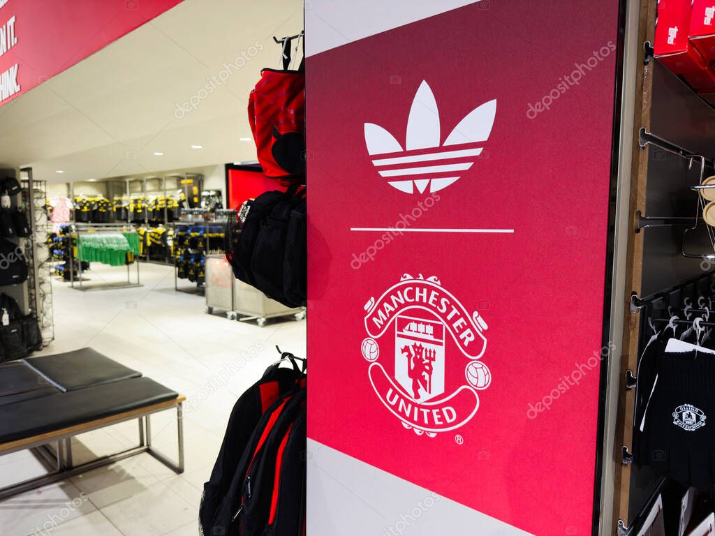 Manchester, UK - September 30, 2025: Adidas branding with the Manchester United crest in a busy Manchester shop showcasing sportswear and apparel.