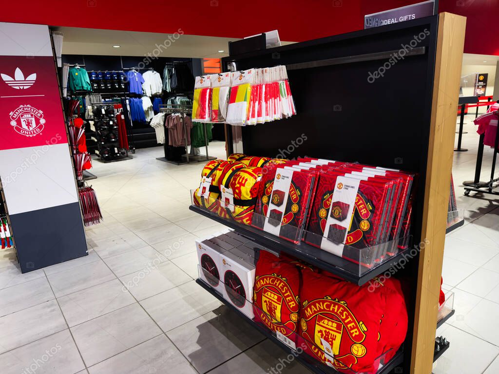 Manchester, UK - September 30, 2025: Bright Manchester shop featuring Manchester United apparel, scarves, and bags in a modern sports retail space.