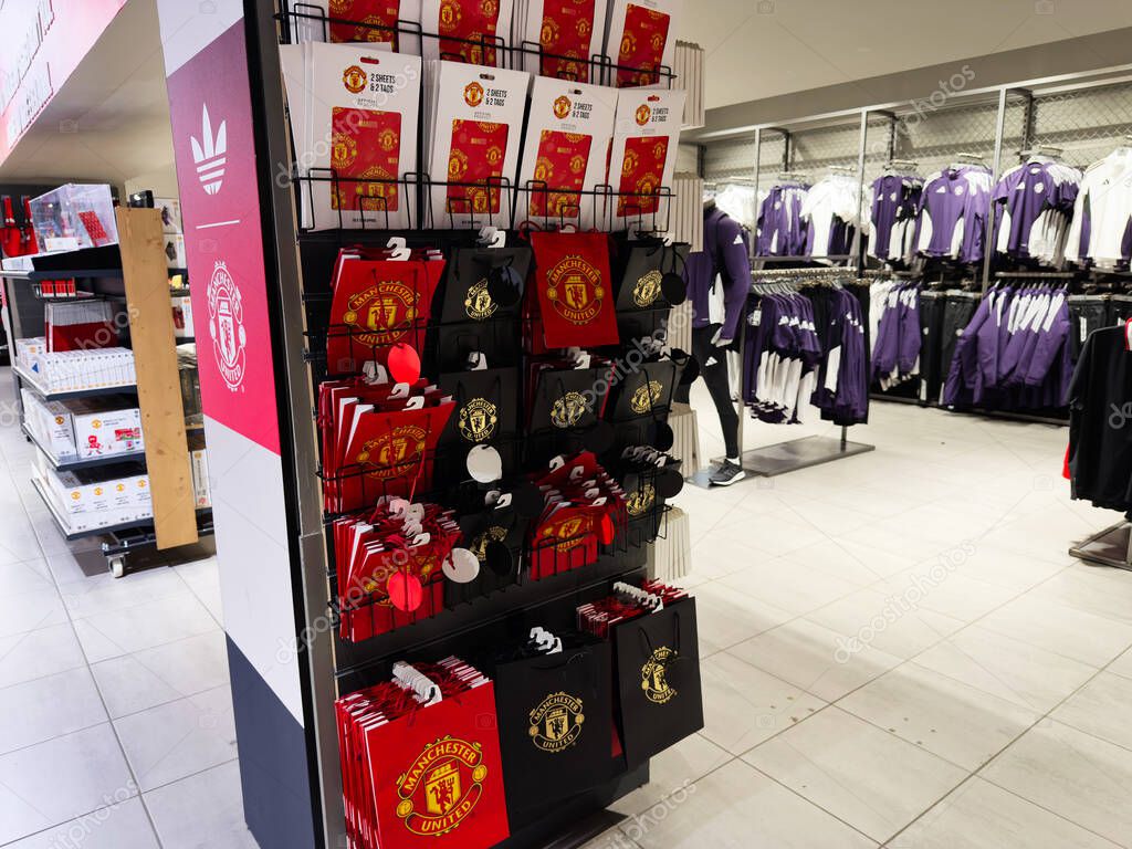 Manchester, UK - September 30, 2025: Manchester store interior showing United branded bags and purple apparel on display.