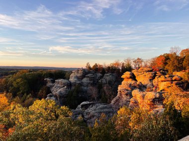 Altın saat ışığı, Colorado 'da geniş bir tepede kumtaşı uçurumları ve sonbahar ağaçlarını yıkıyor..