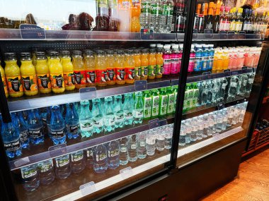 Şimdi Dwy Dwor Mazowiecki, Polonya - 22 Ekim 2025: Bir havaalanı bakkalında cam buzdolabının arkasında sıralanmış çeşitli içecekler.
