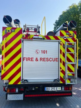 Kyiv, Ukrayna - 10 Kasım 2025: Yüksek görüş mesafesi kırmızı ve sarı sembollü parlak itfaiye aracı, merdivenler ve güvenlik ekipmanları.