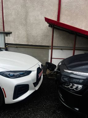 Kyiv, Ukrayna - 10 Kasım 2025: Kırmızı bir tentenin altında beyaz ve siyah arabalar yan yana park edilmiş..