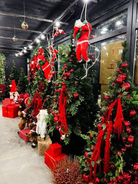 Kyiv, Ukrayna - 10 Kasım 2025: Kırmızı süslemeler, hediyeler ve Noel Baba karakterlerinin yer aldığı canlı bir tatil sahnesi.