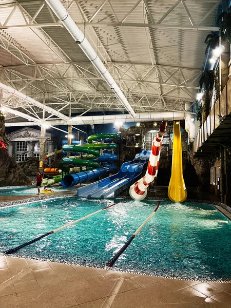 Khmelnytsky, Ukrayna - 10 Kasım 2025: Aile eğlencesi için slaytlar ve parlak havuzlarla dolu canlı kapalı su parkı sahnesi.