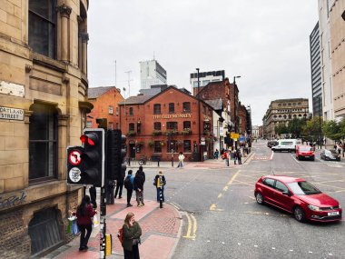 Manchester, İngiltere - 30 Eylül 2025: Manchester Portland sokaklarını yayalar, trafik ve bir tuğla ile doldurmak Bir şehir merkezinde Eski Maymun Pub.
