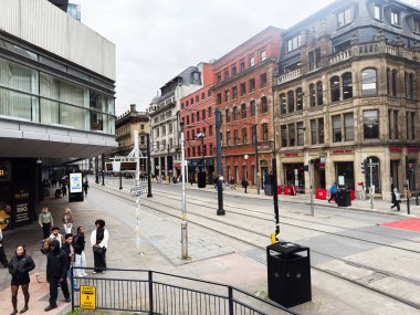 Manchester, İngiltere - 30 Eylül 2025: Tarihi binalar, tramvay rayları ve yayalarla dolu Manchester City Parker Center.