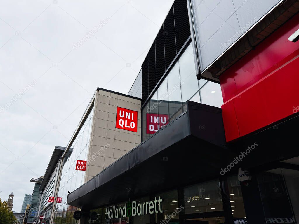 Manchester, UK - September 30, 2025: Modern Manchester shopping center with Uniqlo signage and glass facade, adjacent Holland Barrett storefront.