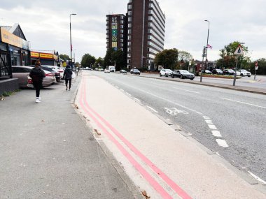 Manchester, İngiltere - 30 Eylül 2025: Yayalar, arabalar, bisikletler ve pembe bisiklet yolu ile dolu Manchester caddesi.