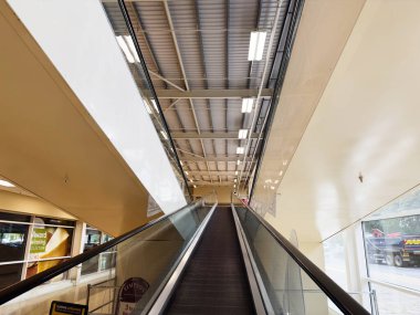 Manchester, İngiltere - 30 Eylül 2025: Tesco Manchester 'da cam raylı ve gün ışığında yürüyen bir yürüyen merdiven.