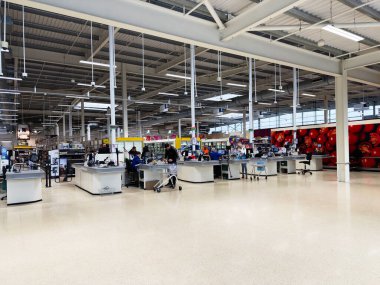Manchester, İngiltere - 30 Eylül 2025: Manchester, İngiltere 'deki Bright Tesco bakkal kasası kasası müşterileri ve alışveriş arabaları.