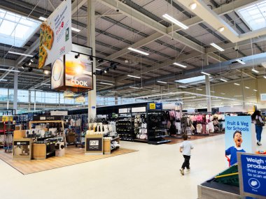 Manchester, İngiltere - 30 Eylül 2025: Manchester İngiltere 'de parlak perakende reyonları ev eşyaları, giysiler ve oyuncu bir çocuk keşifleri.