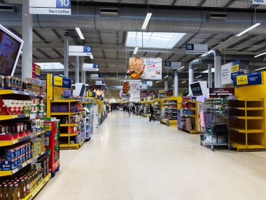 Manchester, İngiltere - 30 Eylül 2025: Parlak tabelalı ve alışveriş yapan Manchester UK süpermarket koridorunun geniş görünümü.