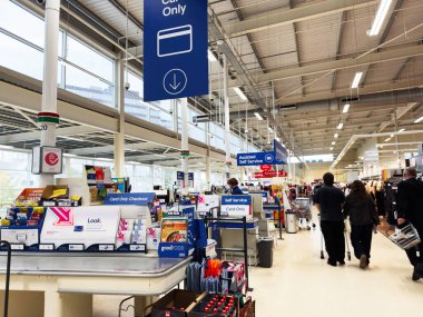 Manchester, İngiltere - 30 Eylül 2025: Bright Manchester self-servis ve destekli çıkış ile müşterilerin kartlarla ödeme yaptığını gösteren.