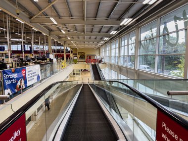 Manchester, İngiltere - 30 Eylül 2025: Yürüyen merdivenleri, büyük pencereleri ve afişleri olan modern Manchester UK alışveriş merkezinin içinde.