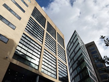 Manchester, İngiltere - Ekim 04, 2025: Gökdelen Piccadilly Place siluetleri ve cam soluklukları Manchester şehir merkezindeki kentsel mimari sahnesine ışık yansıtıyor.