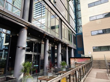 Manchester, İngiltere - Ekim 04, 2025: Manchester kentsel mağaza modern cam cephe Store Street Exchange Restaurant, sicim ışıkları, saksılar ve yükseltilmiş bir yürüyüş yolu.
