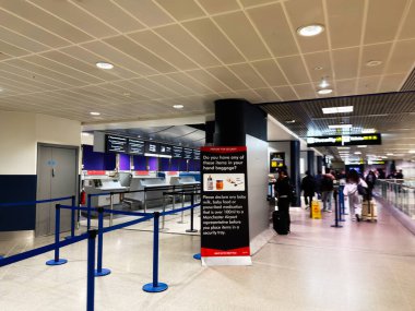 Manchester, UK - October 04, 2025: Passengers queue at security counters in Manchester Airport, guided by signs and staff, awaiting screening.