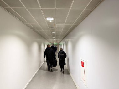 Manchester, İngiltere - Ekim 04, 2025: Gezginler Manchester, İngiltere 'de modern bir ulaşım terminalinde parlak bir koridor boyunca yürürler.