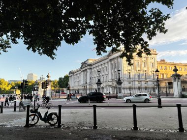 Londra, İngiltere - 22 Eylül 2025: Güneşli Londra sahnesi tarihi bir beyaz hükümet binasını, kapıları, arabaları ve yayaları gösteriyor.