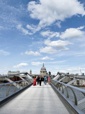 Londra, İngiltere - 22 Eylül 2025: Londra 'da St Pauls Katedrali ve mavi gökyüzü ile modern bir köprü boyunca yoğun bir grup geziniyor.