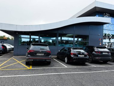 Dublin, İrlanda - 21 Ekim 2025: Elma yeşili benzin istasyonu ön cephesi İrlanda 'da işaretli bir alana park edilmiş çok sayıda araba.