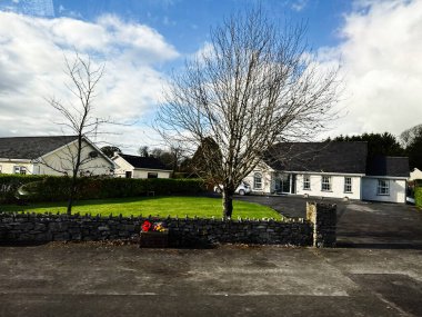 Curraghmore, İrlanda - 21 Ekim 2025: Taş duvarı, çıplak ağaçları ve iyi korunmuş çimleri olan sessiz bir İrlanda evi.