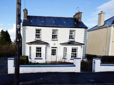 Carrownageelaun, İrlanda - 21 Ekim 2025: İrlanda 'da küçük bir ön bahçesi ve mavi kayrak çatılı beyaz iki katlı ev.