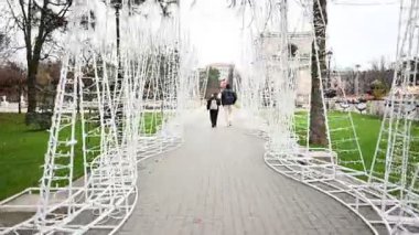 Chisinau, Moldova - 22 Kasım 2025: İnsanlar Moldova 'nın Chisinau kentindeki Zafer Kemeri' ne doğru güzel dekore edilmiş bir patika boyunca yürüyorlar.