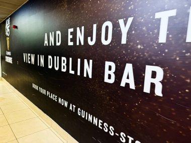 Dublin, İrlanda - 21 Ekim 2025: İrlanda 'daki Dublin bar ve Guinness Deposuna ziyaretçiler davet eden iç duvar reklamı.