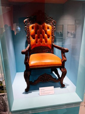 Tık, İrlanda - 22 Ekim 2025: Süslü ahşap papalık koltuğu turuncu döşemeli, Knock, İrlanda 'da cam bir ekranda sergileniyor.