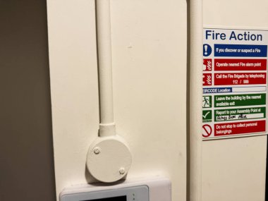 Tık, İrlanda - 22 Ekim 2025: Acil yangın işaretleri ve duvar paneli Knock, İrlanda 'da bir boru ve vananın yanında talimatlar.