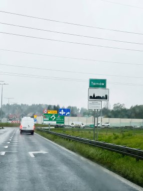 Tarnow, Polonya - 25 Ekim 2025 Tarnow yakınlarındaki bir Polonya otoyolunda birden fazla yol işareti ve araçla yağmurlu bir gün.