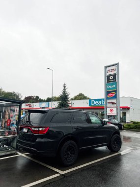 Tarnow, Polonya - 25 Ekim 2025: Koyu renkli bir Dodge Durango SUV gri gökyüzünün altında duruyor.. 