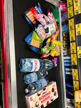 Tarnow, Polonya - 25 Ekim 2025: Renkli abur cubur, şeker ve şişelenmiş su çeşitleri.