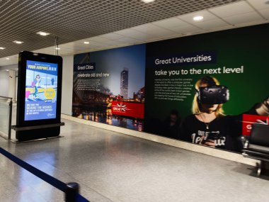 Manchester, İngiltere - 07 Kasım 2025: Manchester, İngiltere 'de gezginlerle birlikte teknoloji ve eğitim temalarının yer aldığı parlak havaalanı gösterisi.