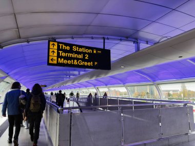 Manchester, İngiltere - 07 Kasım 2025: Manchester istasyonunda açık bir buluşma ve karşılama işareti ve mavi ışıklı tavan ile yoğun yürüyüş yolu.