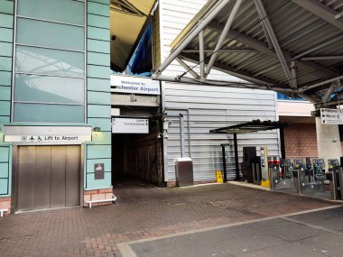 Manchester, İngiltere - 07 Kasım 2025: Manchester Havaalanı 'nın dışı, havaalanı tabelası, modern cam perade ve turnikeleri ile.