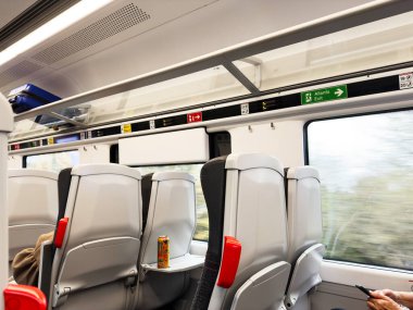 Manchester, İngiltere - 07 Kasım 2025: Manchester 'da oturaklı modern bir tren vagonu, tepside bir konserve ve bulanık bir pencere manzarası.