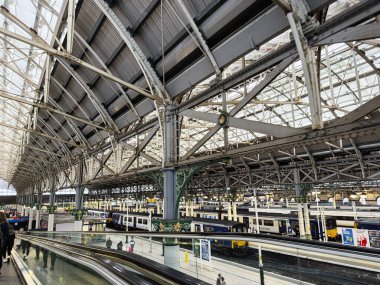 Manchester, İngiltere - 07 Kasım 2025: Süslü çelik kemerleri, platformları ve trenleri olan hareketli bir Manchester tren istasyonu.